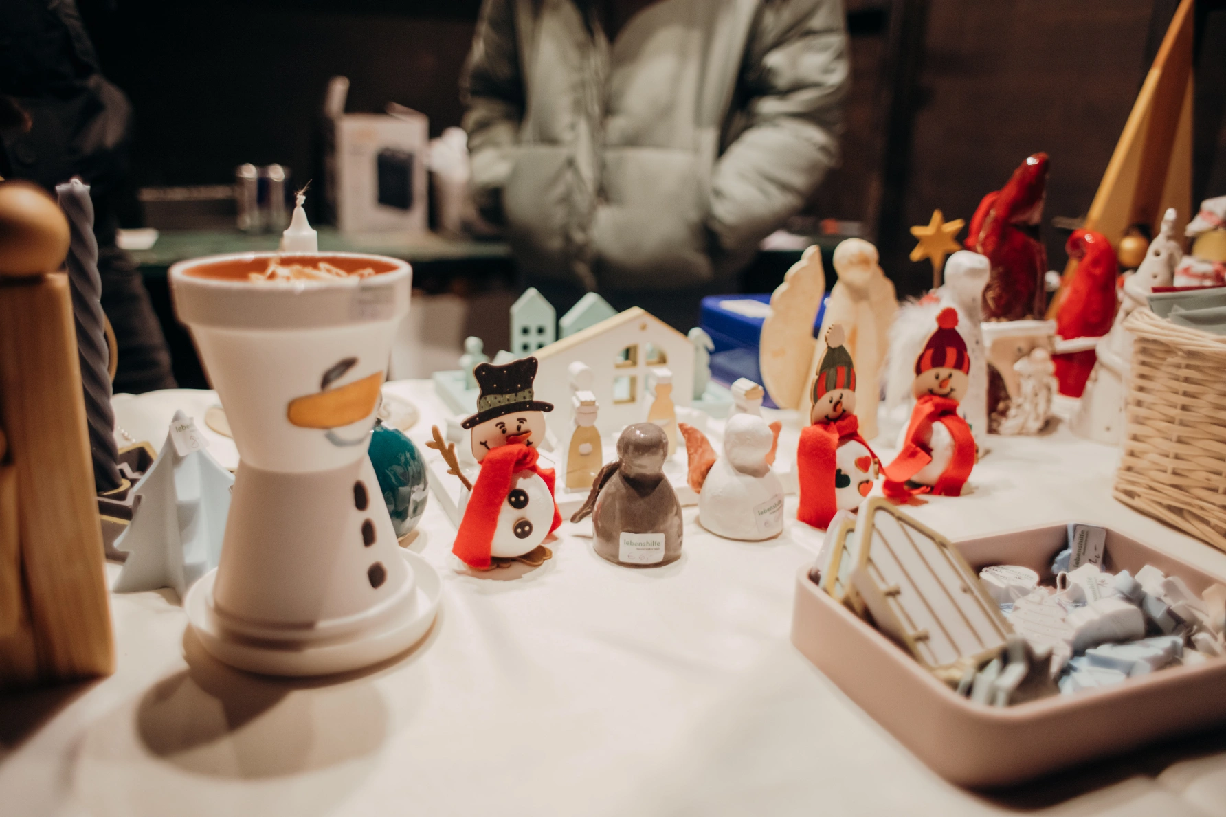 Handgefertigte Weihnachtsfiguren, Schneemänner und kleine Holzhäuser auf einem Kunsthandwerksstand